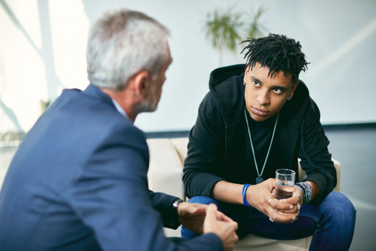 African American adolescent during psychotherapy with mental health professional at counselling center